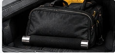Collapsed baton beside a bag in a vehicle trunk